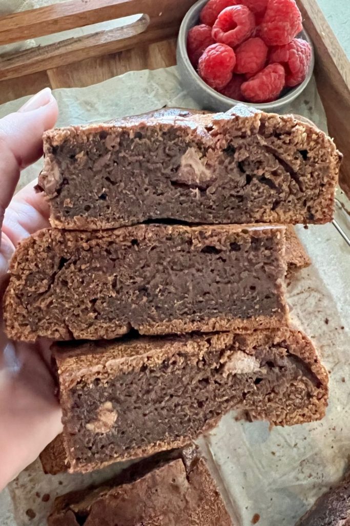 Close up of inside of sourdough chocolate brownie - hand holding three slices of sourdough chocolate brownie.