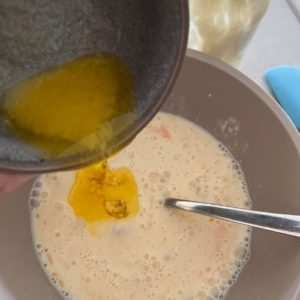 Sourdough discard waffles recipe- adding melted butter to sourdough starter mixture.