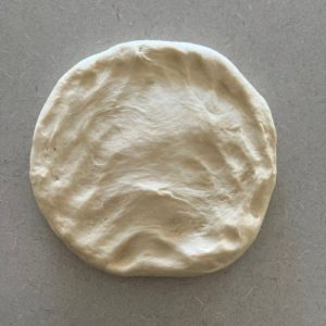 circle of dough turned out on the counter