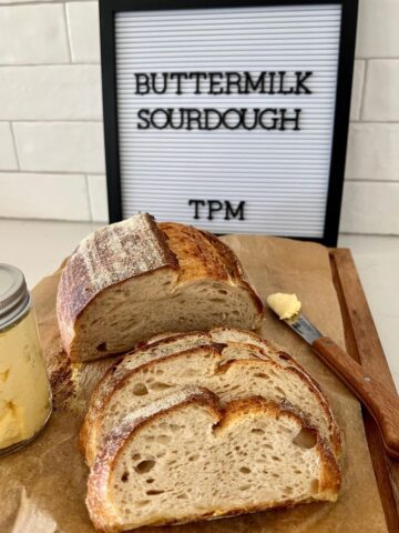 Buttermilk sourdough bread sitting on a wooden bread board
