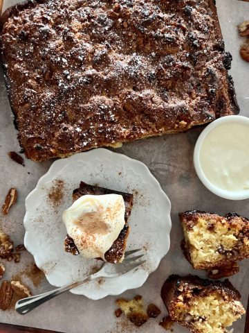 How to add sourdough discard to any recipe - including this cinnamon coffee cake. The coffee cake has been cut up into pieces and is sitting with a bowl of double cream.